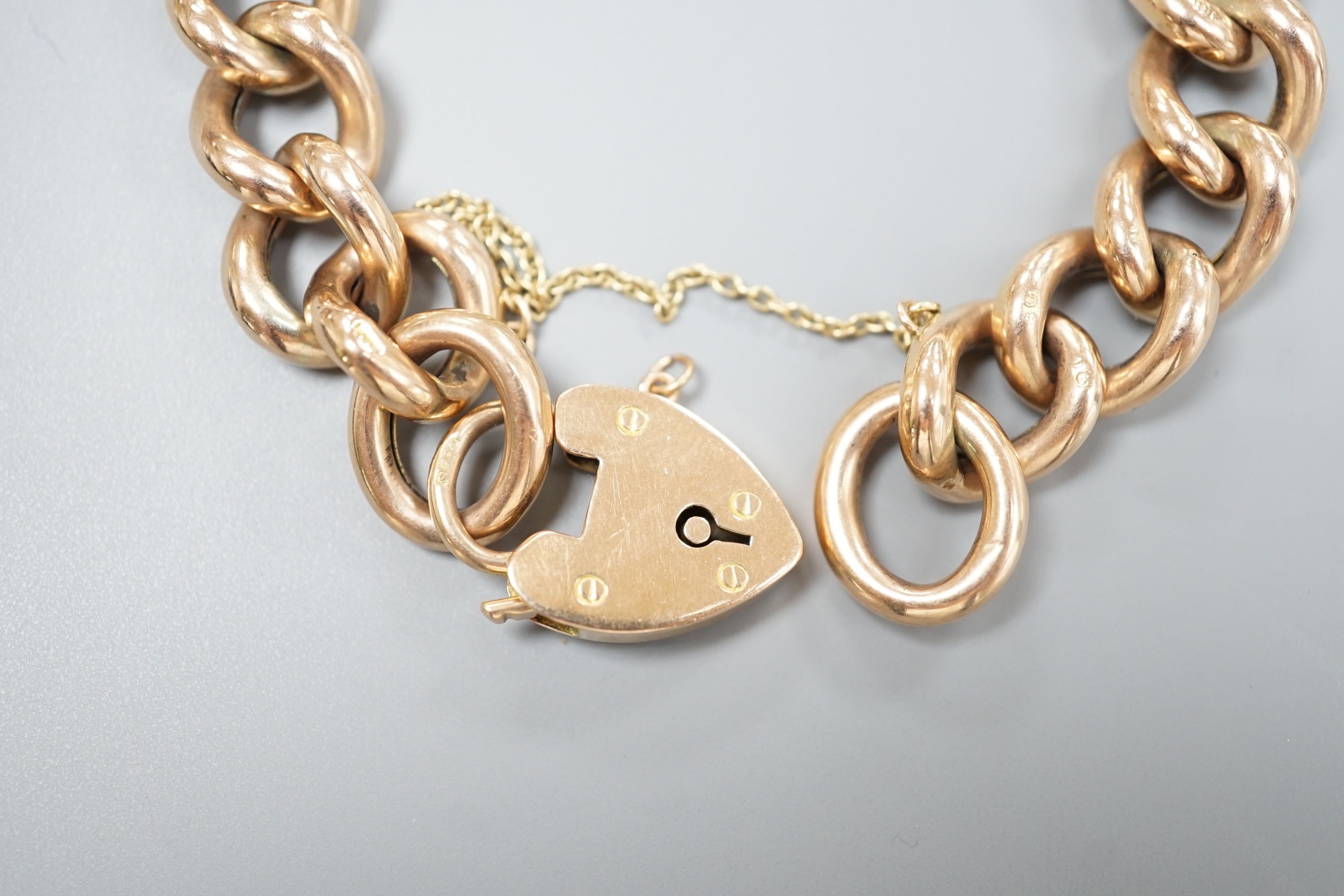An Edwardian 9ct gold curblink bracelet, with heart shaped padlock clasp, approx. 19cm, 20.3 grams.